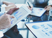 hands holding tablets with business data