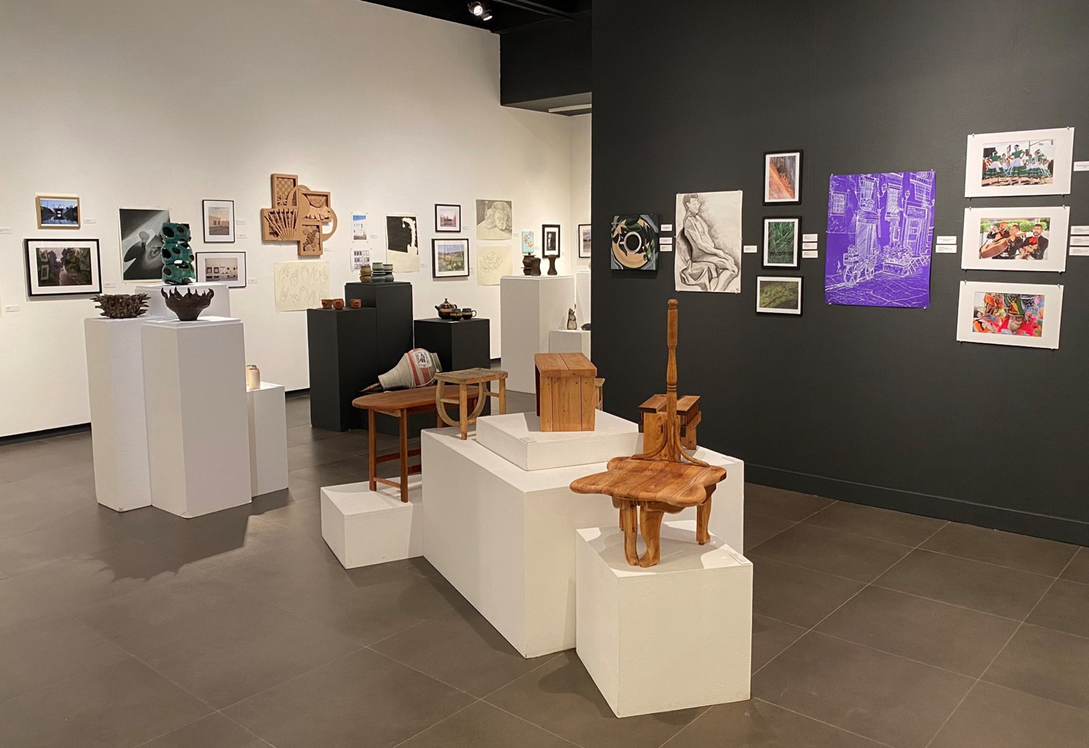 wood sculpture and student paintings in art gallery