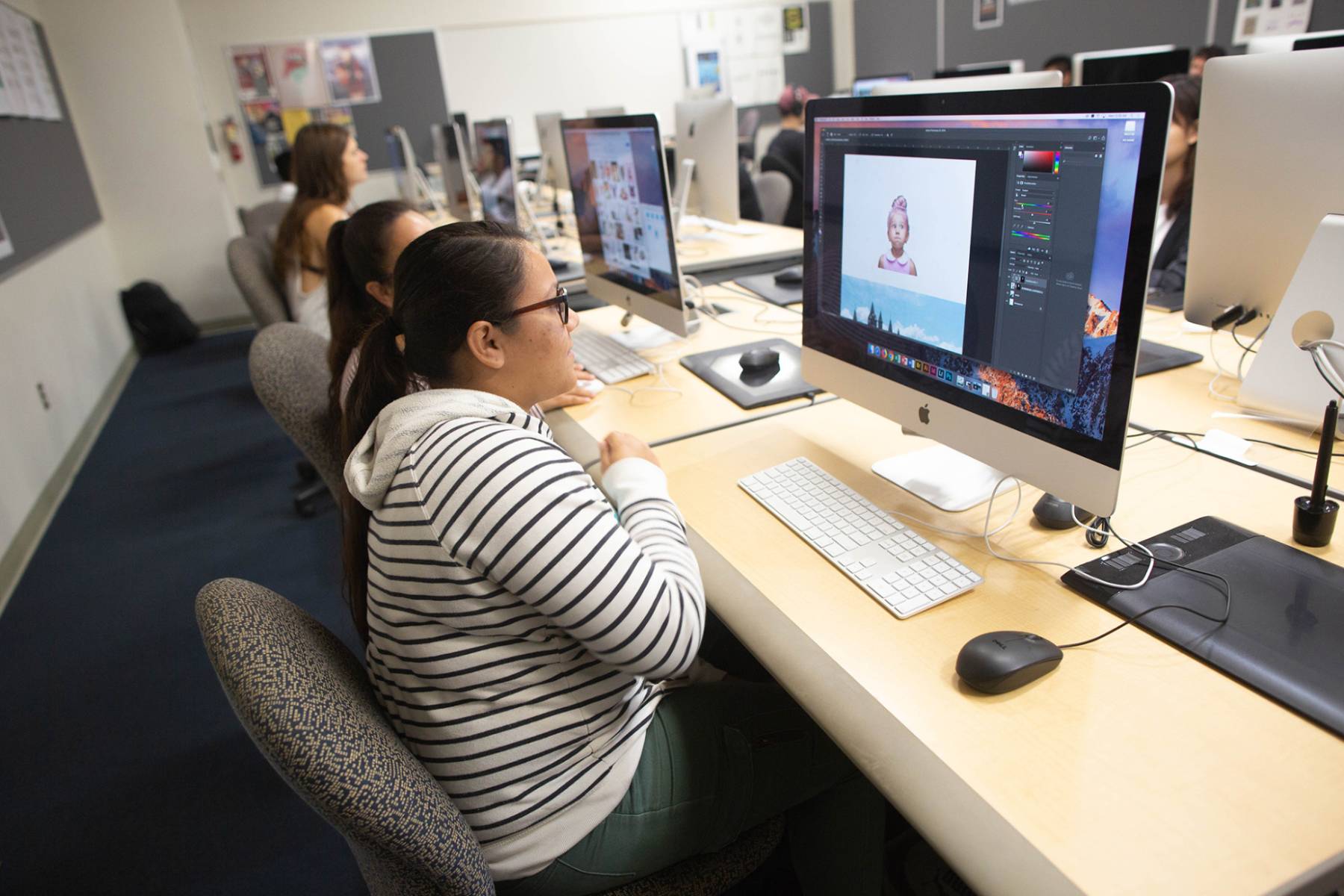 Female graphic design student sitting in front of computer