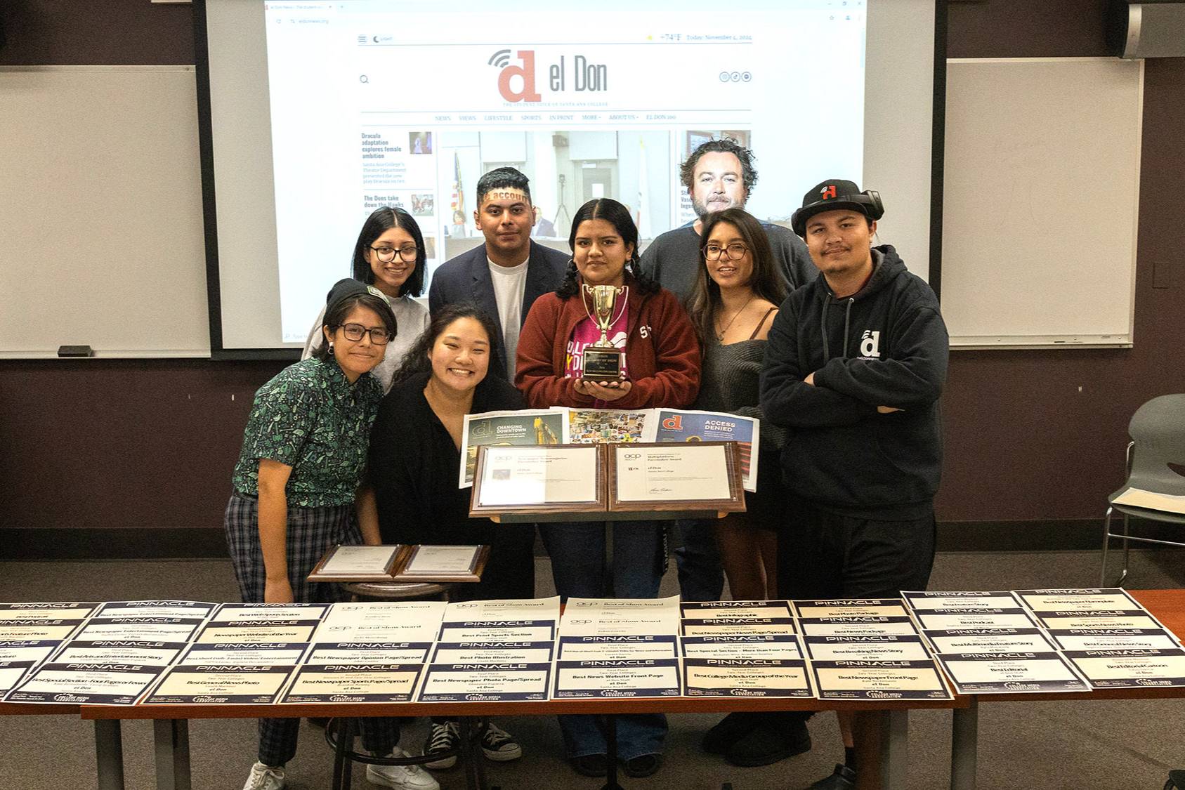 Santa Ana College Journalism students holding up awards