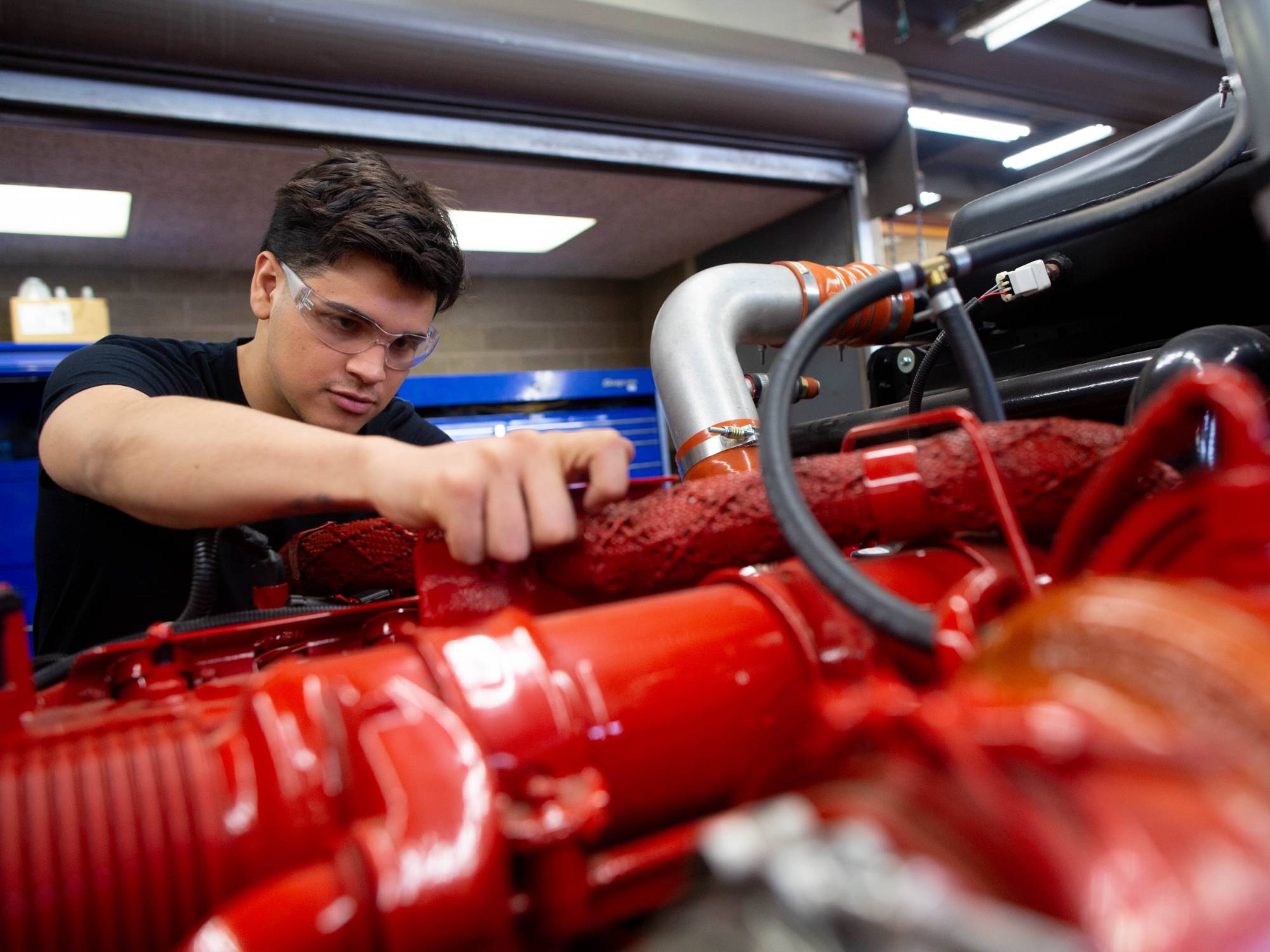 male student fixing up a diesel engine