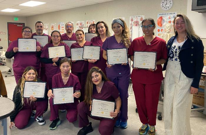 Excited students receiving caregiver personal aide certificates and starting new careers in healthcare in Orange County, California.