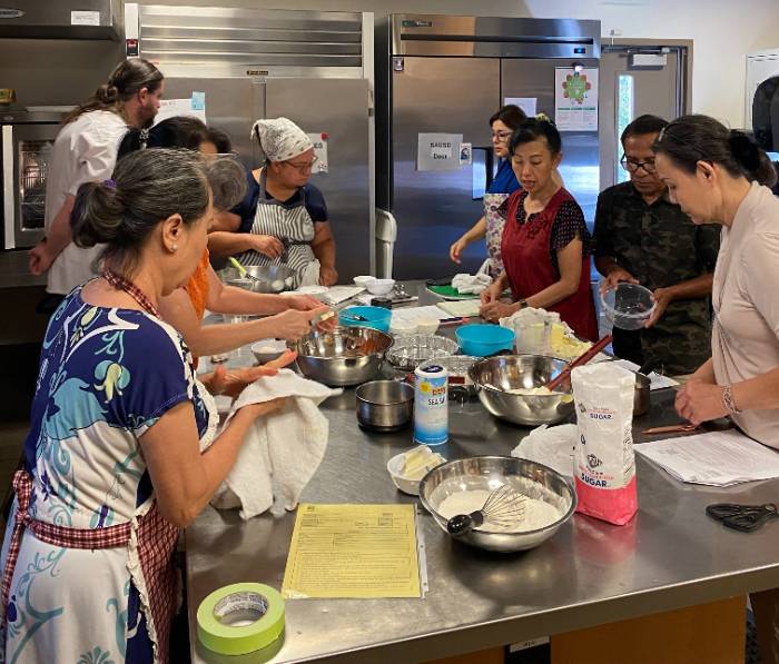 Diverse students of all ages in kitchen learning baking and pastry skills with free in-person classes with Santa Ana College School of Continuing Education.